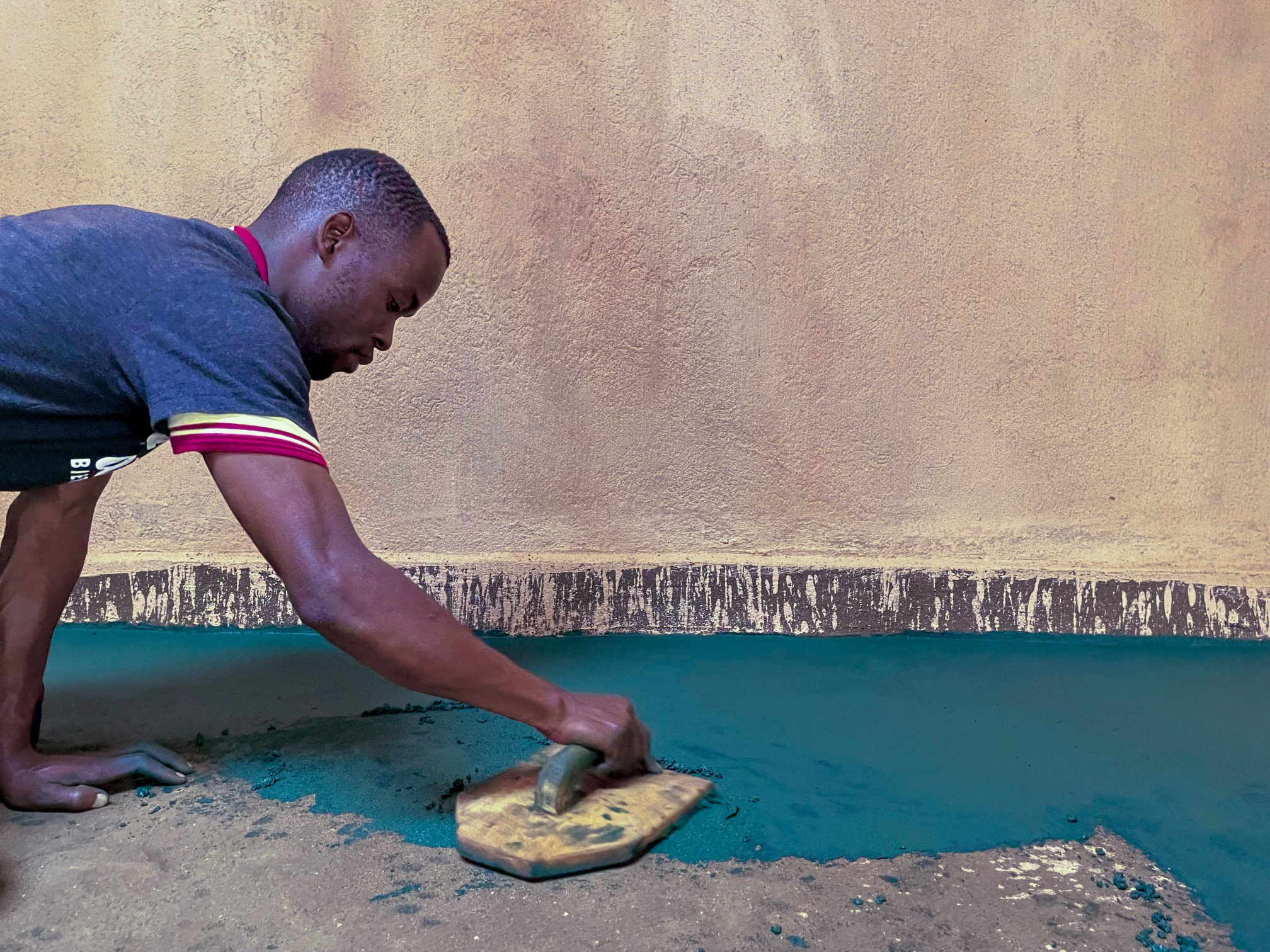 A trained Nyumba Nzuri artisan with a family in their finished home
